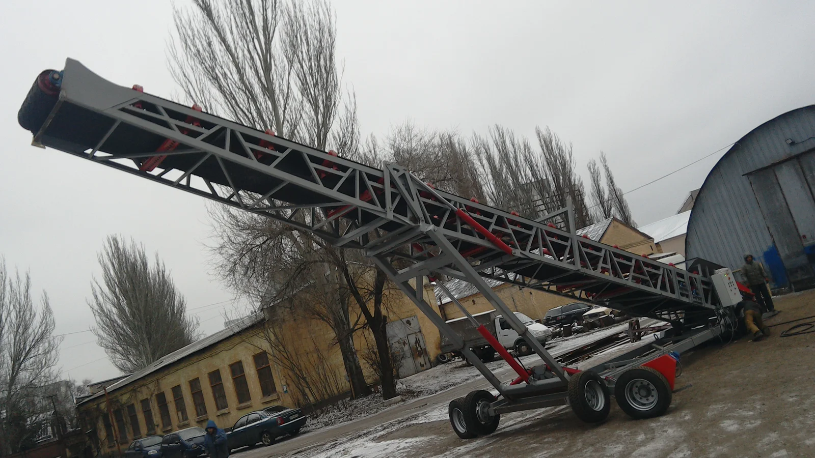 Wheeled mobile conveyor with an inclined boom