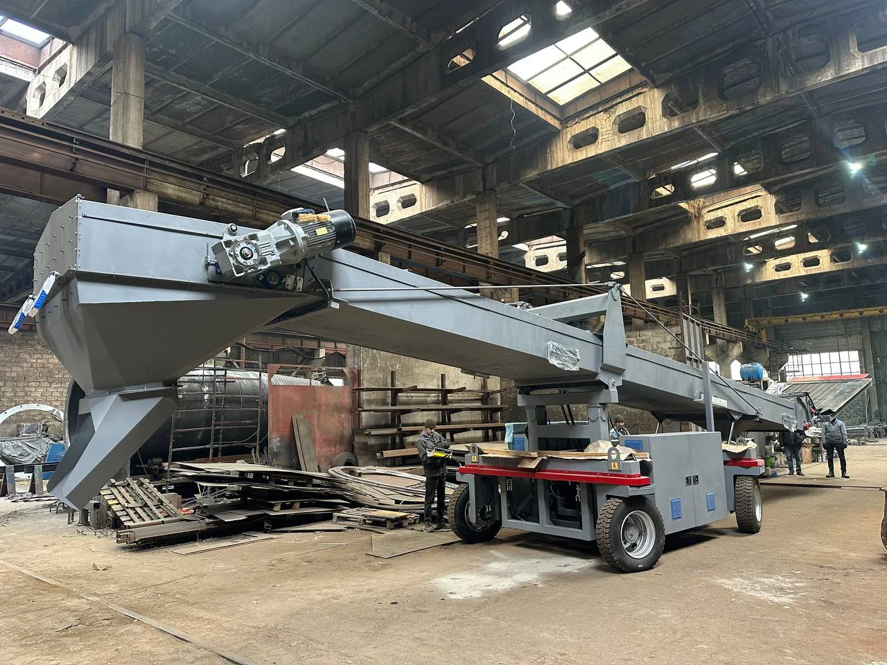 Self-propelled mobile transfer conveyor in a workshop