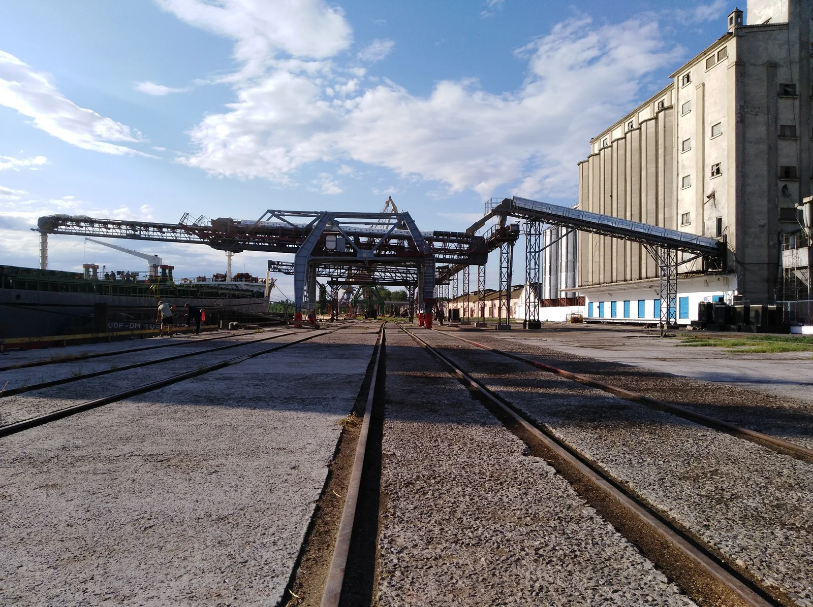 Conveyor-fed shiploader alongside a grain storage building