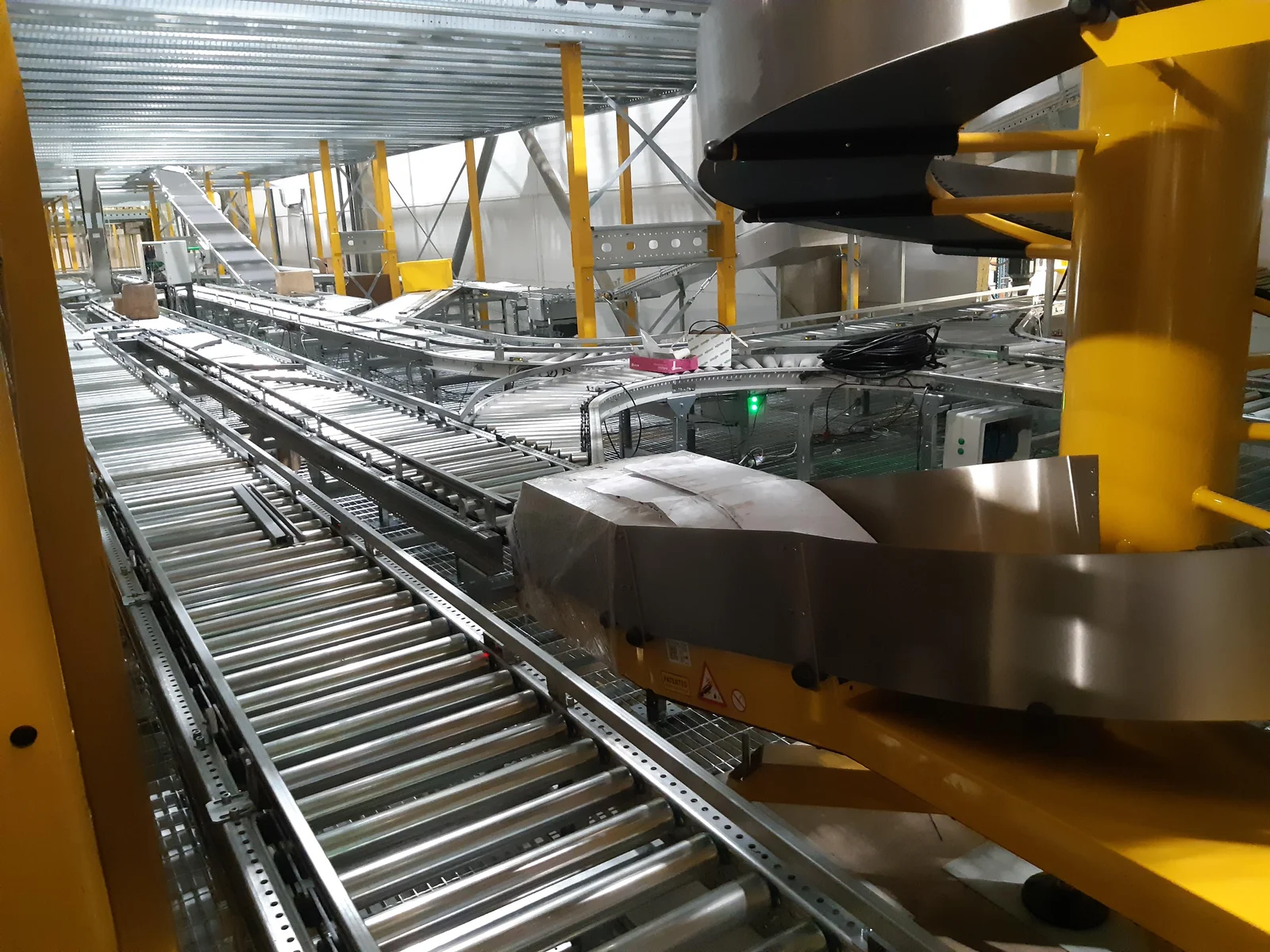 Automation mechanism beside a roller conveyor