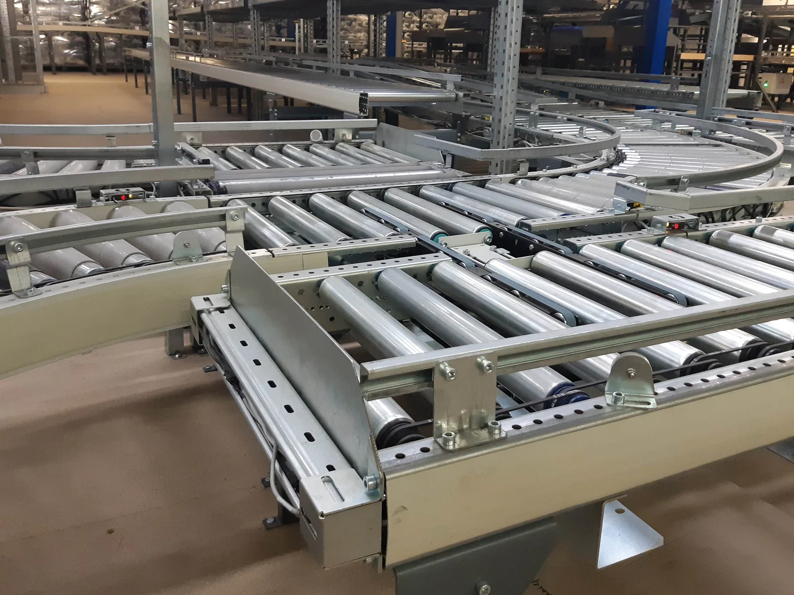 Roller conveyor junction with integrated transfer mechanisms